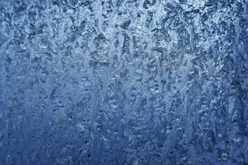 Frozen pattern of hoarfrost and frostwork structure on the glass. Color texture photo for background.