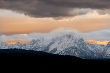 Obraz premium USA, Wyoming, Grand Teton National Park. Sunrise lights clouds over Teton Range.