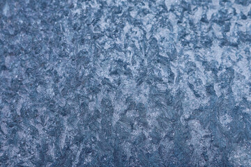 Frozen pattern of hoarfrost and frostwork structure on the glass. Color texture photo for background.