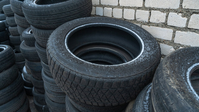 Storage of discarded old car tires outdoors, showcasing a pile of used tires ready for recycling. Highlighting environmental concerns and rubber waste management