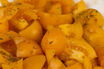 ripe orange tomatoes with spices cut into pieces of different sizes