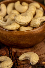 large cashew nuts are scattered on a larch board