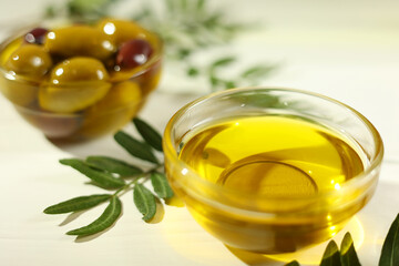 A premium olive oil with olives and fresh leaves, top view 