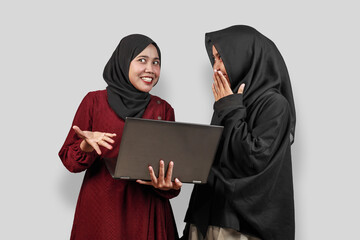 Two Muslim Women Wearing Hijab Laughing While Using Laptop