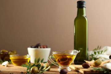 A beautifully arranged Olive Oil Bottle alongside Fresh Olives and vibrant Green Leaves 