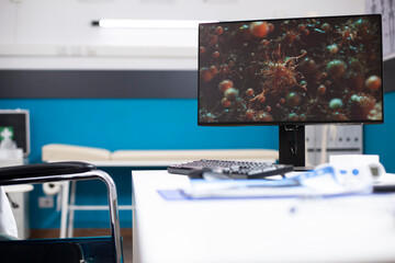 Doctors office with desktop monitor showing cell images, symbolizing healthcare commitment to epidemic research. Empty clinic room with computer, ready for advanced digital treatment of flu viruses.