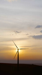 Obraz premium Close-up wind turbines or wind energy converter in sunny day with sunset sky. Windmill farm. Sustainable energy production. Green Energy, clean power, clean energy concept. 