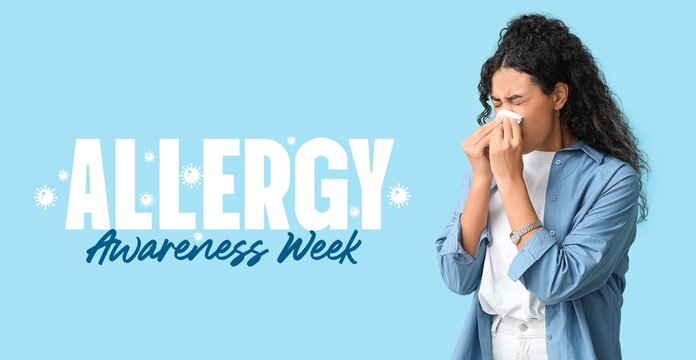 Banner for Allergy Awareness Week with young African-American woman blowing nose - Powered by Adobe