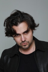 Headshot handsome man wearing black jacket and looking at the camera. Vertical.