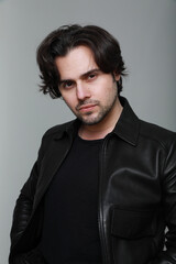 Obraz premium Handsome man wearing black jacket and looking at the camera. Vertical.
