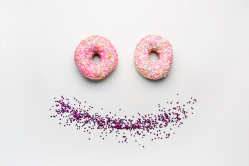 Smile made of donuts with confetti on white background