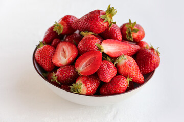 Bowl with fresh strawberries on white background