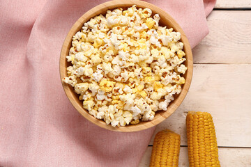 Bowl with tasty popcorn on white wooden background