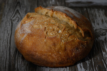 Freshly baked rustic bread resting on a wooden table in a warm kitchen atmosphere
