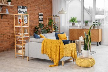 Interior of modern living room with grey sofas, pouf and houseplant