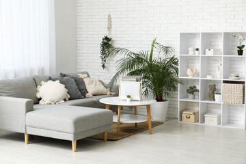 Stylish living room with grey sofa, soft pillows and coffee table