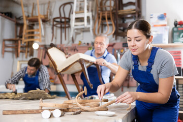 Portrait of skillful repair woman carpenter renovating chair furniture using tools in woodwork studio