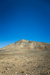 Strange, lunar landscape of the Fuerteventura volcanos and dirt roads in the interior of the island. Mountains, sands