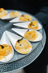 Tasty appetizer served in small porcelain spoons at a lively culinary event