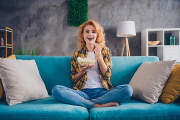 Full length photo of lovely young blonde girl eat popcorn watch movie dressed yellow plaid garment...