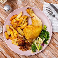 Closeup of baked chicken legs with potatoes