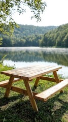 Obraz premium A wooden picnic table by a serene lake surrounded by lush greenery and misty hills.