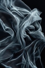 Obraz premium Dramatic image of black fabric dynamically blowing against a black background, capturing movement and texture.