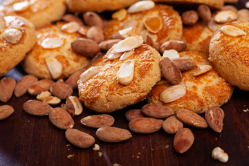 Delicious pastries, shortbread cookies with almonds on wooden background