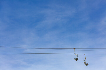 Minimalist photograph of empty chairlift against a clear blue sky showcasing tranquility and open space