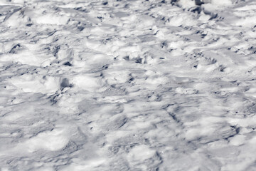 Textured view of a snowy surface displaying intricate patterns under natural light