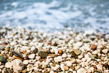 Colorful Pebble Beach Near Ocean Waves in Summer Lighting