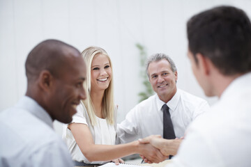 Meeting, business people and client with handshake for introduction, teamwork or financial deal. Office, employees and investor with shaking hands for welcome, partnership or agreement for investment © StigSteex/peopleimages.com