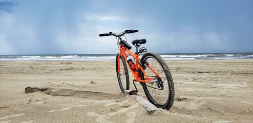 orange bicycle on a deserted beach
