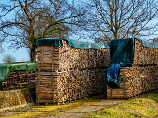 Abgedecktes und gestapeltes Brennholz im Freien