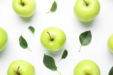 Green apples and leaves on white background, flat lay