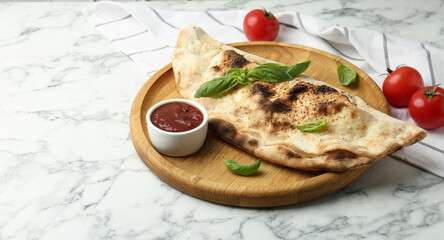 Delicious calzone served on white marble table, space for text