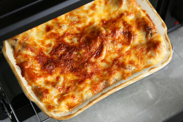 Baking dish with delicious cooked lasagna in oven, above view