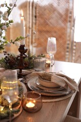 Christmas place setting with festive decor on wooden table in room