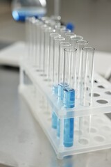 Test tubes with blue liquid on table in laboratory, closeup