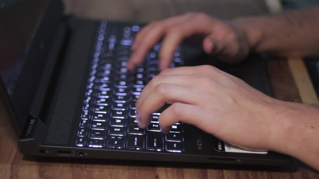 Close up de las manos de un escritor usando el teclado de una laptop.