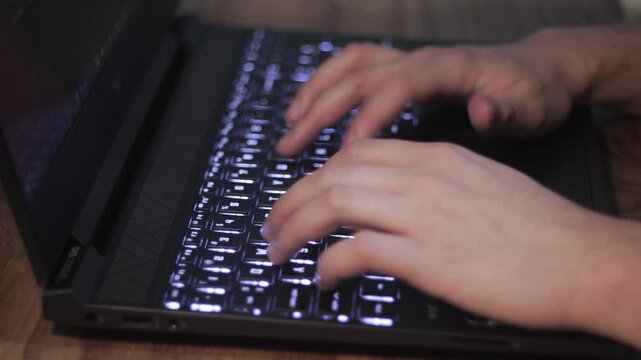 Manos de un escritor usando el teclado de una laptop.