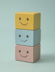 Obraz premium Happy wooden blocks stacked in pastel colors on soft background