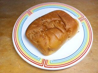 Sweet bread on a plate on a wooden table. Food photography concept for culinary products or advertisements and blog posts. Close up. Copy space. Selective focus.