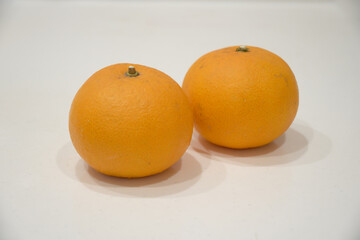 白いテーブルに置かれた2つのみかん