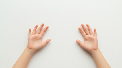 pair of small hands resting on white surface, showcasing delicate fingers and gentle posture. image evokes sense of innocence and curiosity