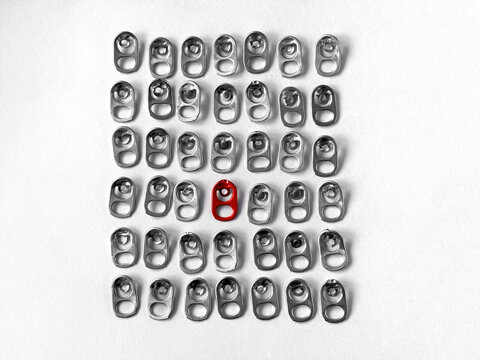 Used aluminum seals from beer can on white paper background, closeup recyclable material. Rings pull tub opener of soda or beer can