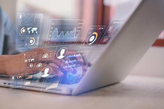 A businessman is sitting at desk typing on computer laptop working with data charts, DEVOPS data analysis and development digital information and technology - Powered by Adobe