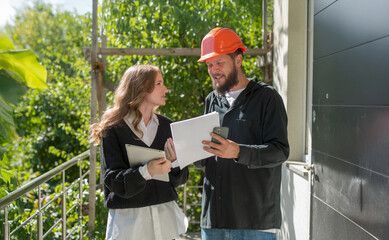customer architect and builder contractor at construction site discuss calculate plan inspect
