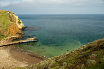 Obraz premium Kayaks Float Around the Dock At Scorpion Beach In Santa Cruz Island