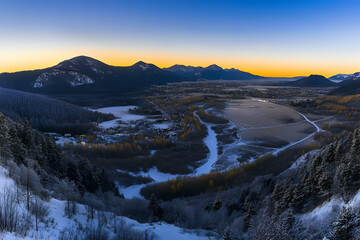 Snowy Mountain Valley Illuminates at Golden Hour Sunset During Winter